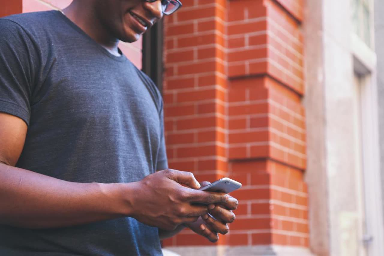 Man on the street checking a notification on his phone