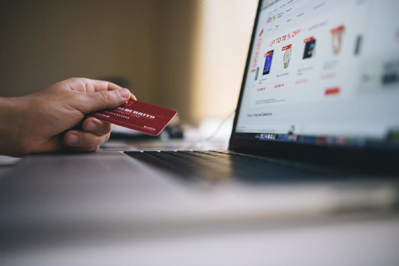 Person shopping online with a card in front of a web store