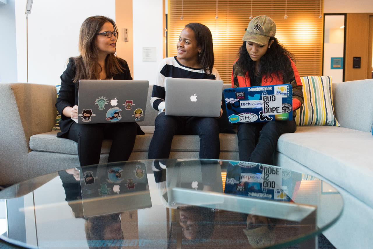 Three startup developers work together on their laptops in an office lounge